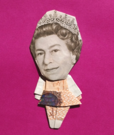 Origami figure of a queen made from banknotes, featuring a crown and colourful dress.