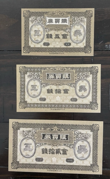 Three vintage banknotes in varying sizes, featuring intricate designs and Chinese characters.