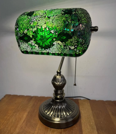 Green art deco lamp with a textured shade and ornate metallic base.